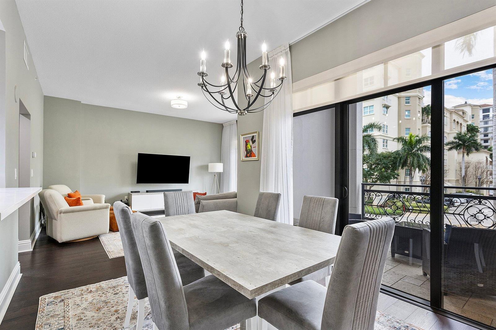 A dining area with a grey table and chairs sits beside a balcony with palm trees — 200 E Palmetto Park Road # 10, Boca Raton FL 33432, BOCA RATON, FL