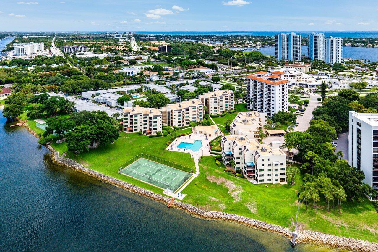 Aerial view of a waterfront residential complex featuring a swimming pool and tennis court — 372 Golfview Road # 101, North Palm Beach FL 33408, NORTH PALM BEACH, FL