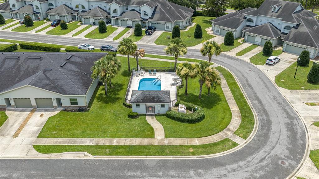 An aerial view shows a community swimming pool and clubhouse surrounded by residential townhomes — 3415 W ANTHONY ROAD UNIT 404, OCALA, FL