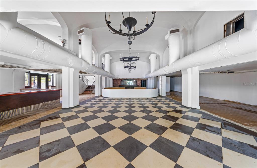 A large, empty room features a black-and-white checkered floor, white arched ceilings, and exposed ductwork — 201-202 TIZOL STREET, SAN JUAN, PR
