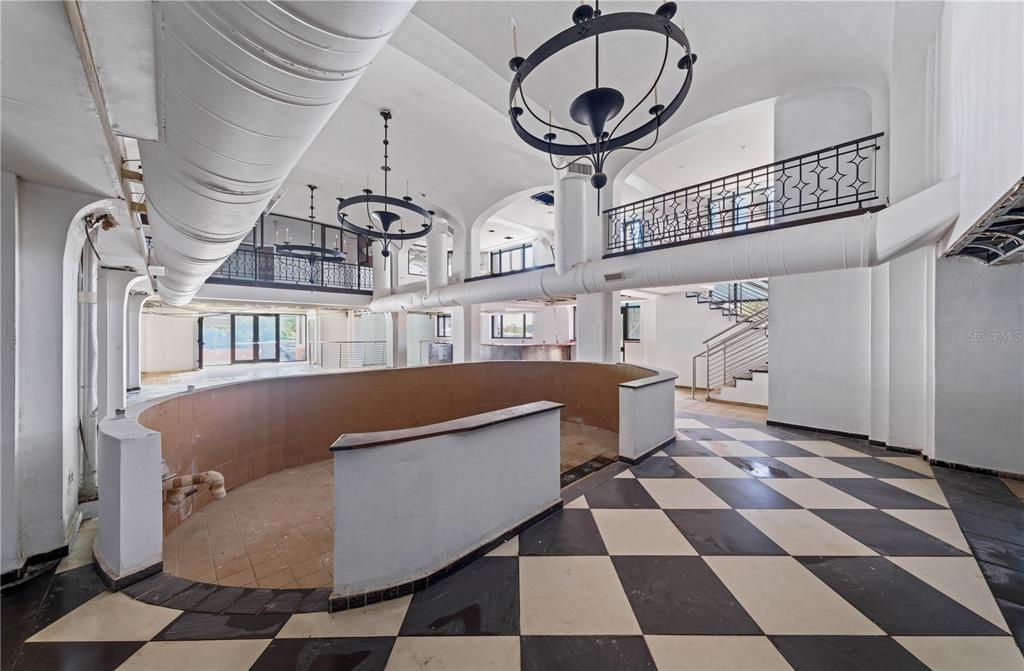 A large, unfinished room features a curved tiled bar, checkerboard flooring, and two hanging chandeliers — 201-202 TIZOL STREET, SAN JUAN, PR