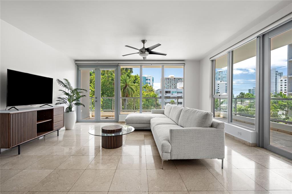 A modern living room features a light gray sectional sofa, glass coffee table, and tile floors — 59 LIRIO UNIT 301, CAROLINA, PR