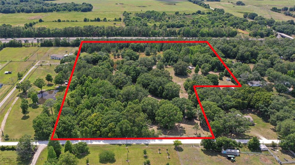 An aerial view shows a large, wooded plot of land outlined in red — 14815 SHERROD CROFT LANE, DADE CITY, FL