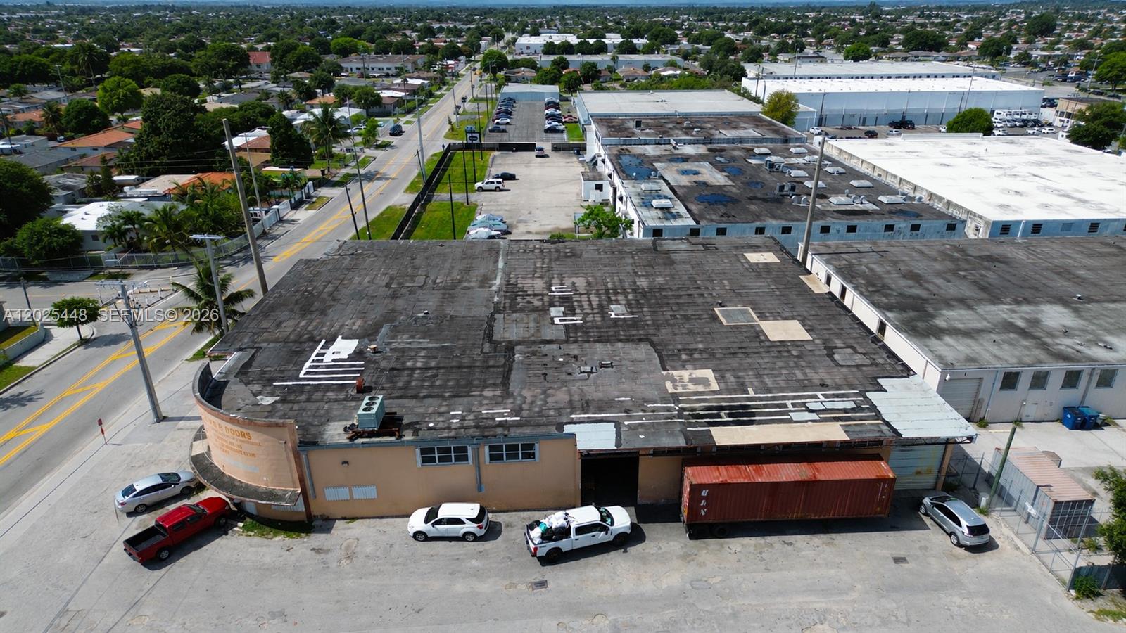 An aerial view shows a commercial building with a flat roof and a parking lot — 455 E 10th Ave, Hialeah FL 33010, HIALEAH, FL