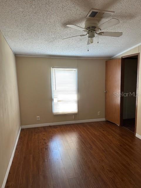 An empty bedroom features wood-look flooring, a ceiling fan, and a window with white blinds — 5705 MIDDLESEX DRIVE, TAMPA, FL