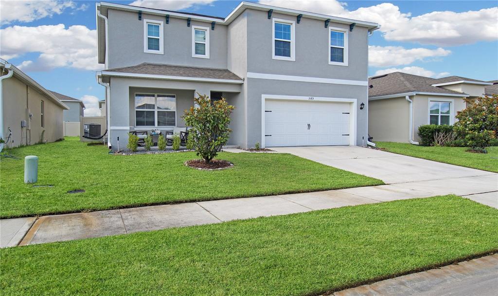 A two-story gray house with a white garage door and a front lawn — 3165 EASTGROVE TERRACE, SANFORD, FL