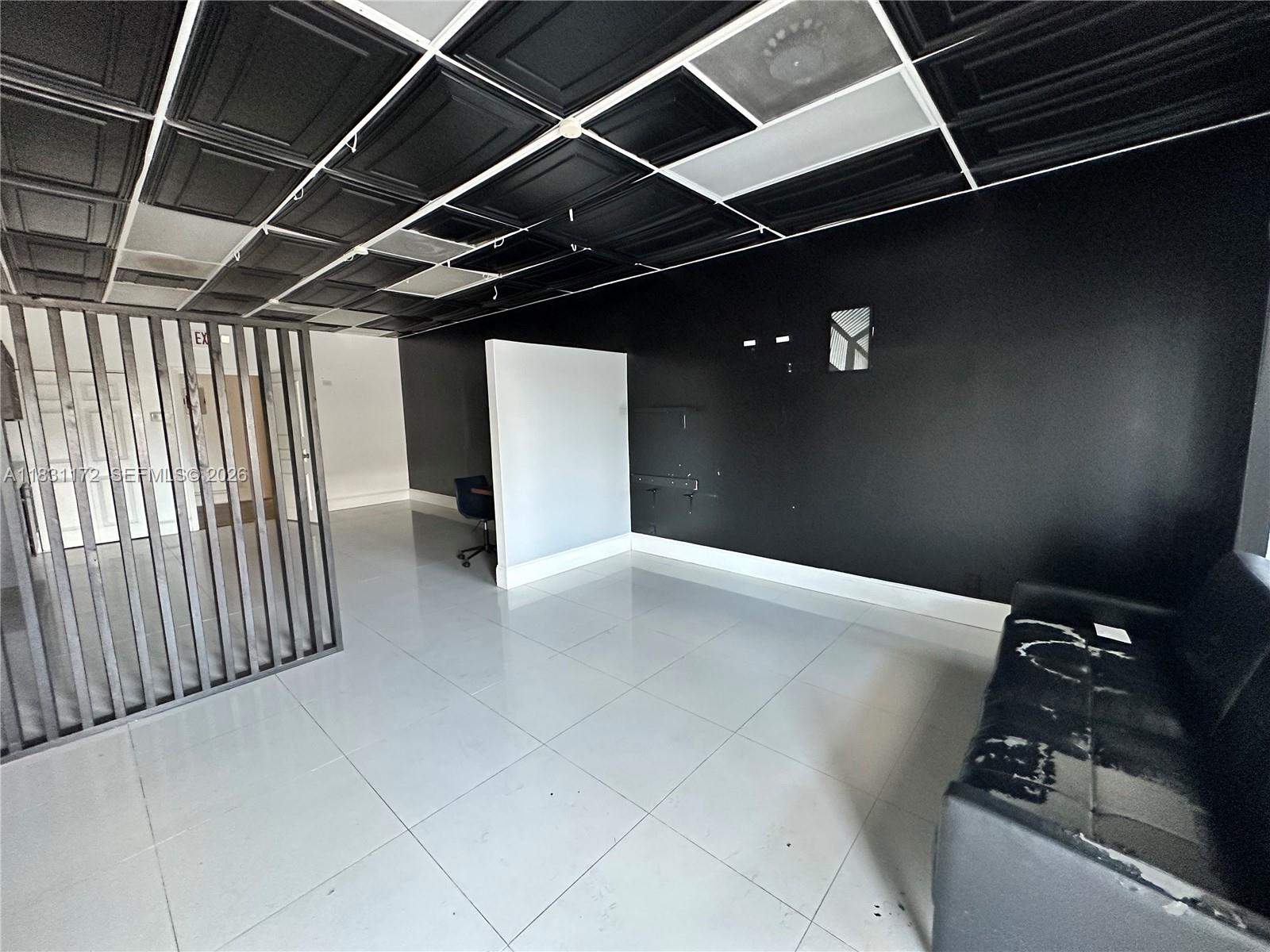 An office space features black ceiling tiles, a black accent wall, and a slatted room divider — 2922 N State Road 7 # 2934, Margate FL 33063, MARGATE, FL