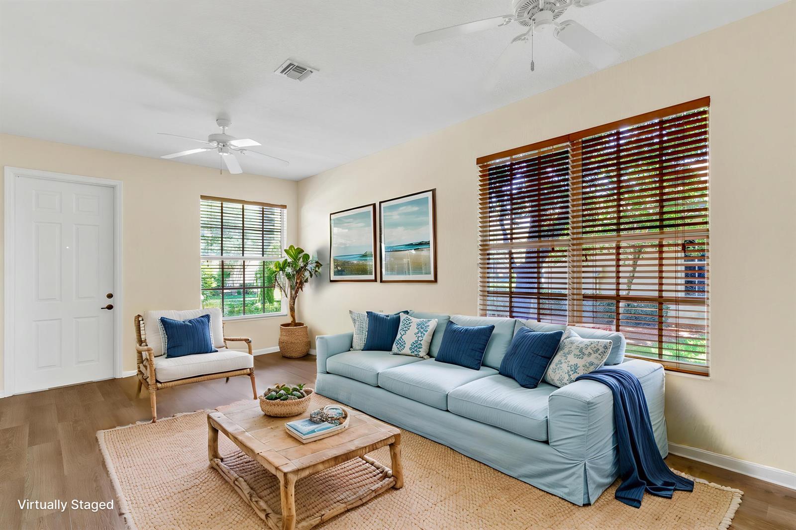 A living room features a light blue sofa, a wooden coffee table, and wood-look flooring — 9975 E Villa Circle, Vero Beach FL 32966, VERO BEACH, FL