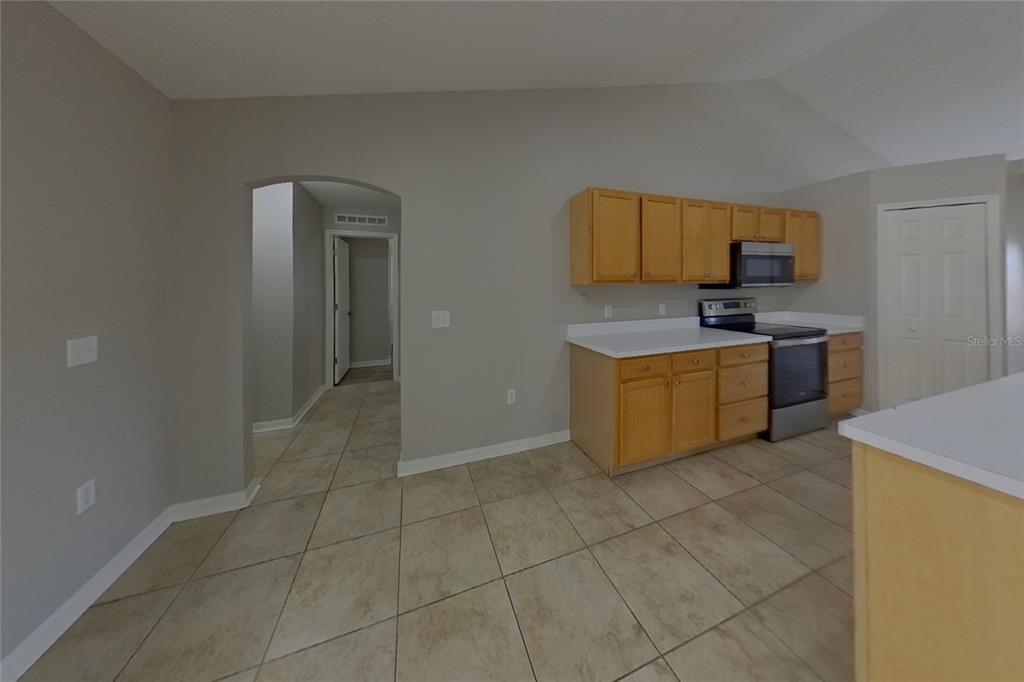 A kitchen with light wood cabinets, white countertops, and tile flooring — 921 JAYHIL DRIVE, MINNEOLA, FL