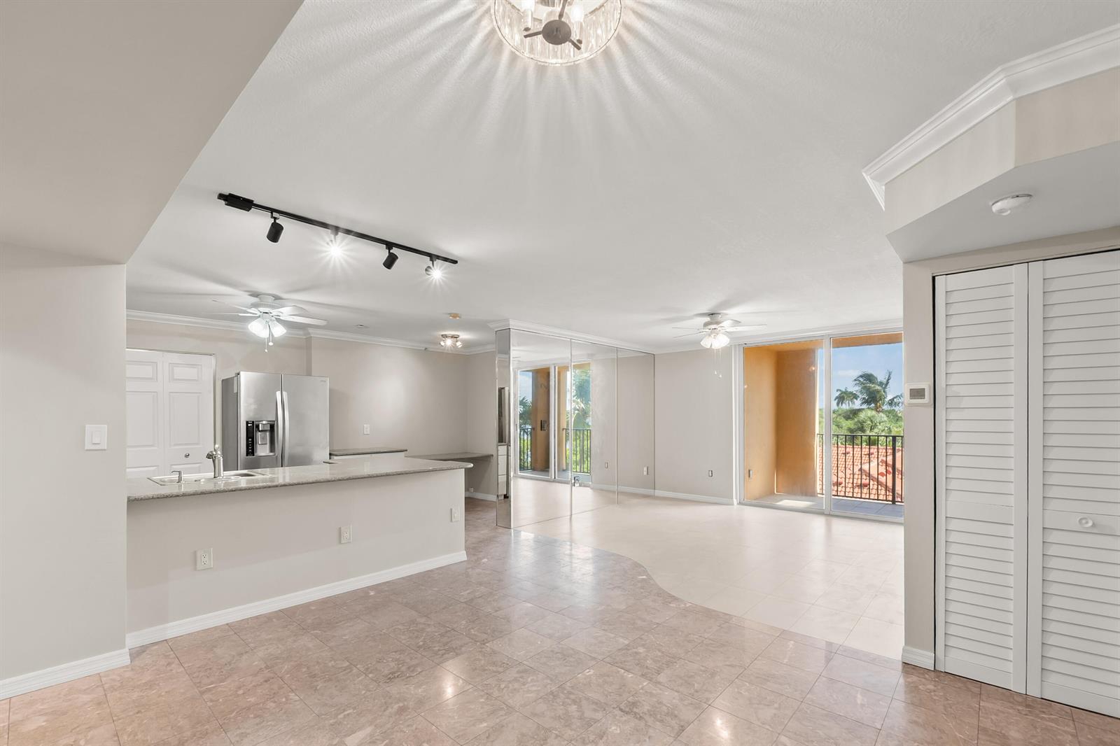 An open-concept kitchen and living area features tile flooring, a breakfast bar, and balcony access — 1200 Scotia Drive # 403, Hypoluxo FL 33462, HYPOLUXO, FL