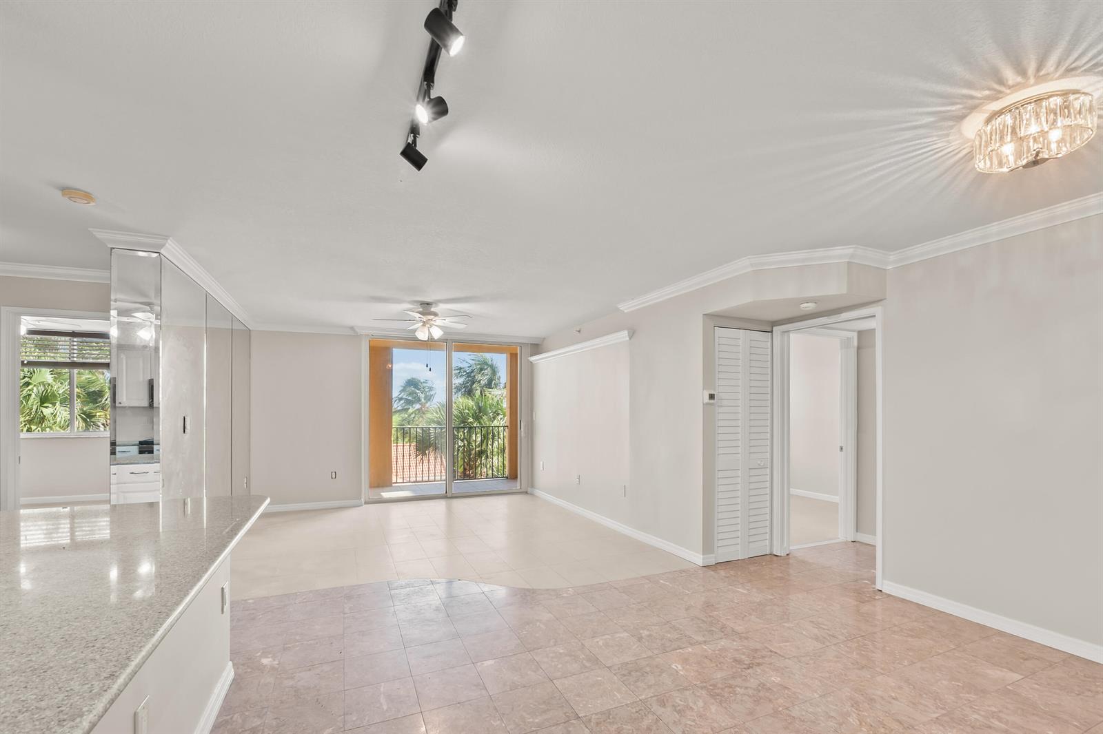An open-concept living and dining area features tile flooring, a balcony, and recessed lighting — 1200 Scotia Drive # 403, Hypoluxo FL 33462, HYPOLUXO, FL