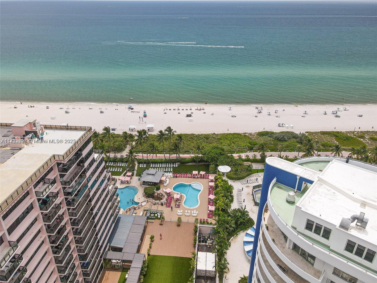 An aerial view shows two high-rise buildings with swimming pools overlooking a sandy beach — 5161 Collins Ave # 812, Miami Beach FL 33140, MIAMI BEACH, FL