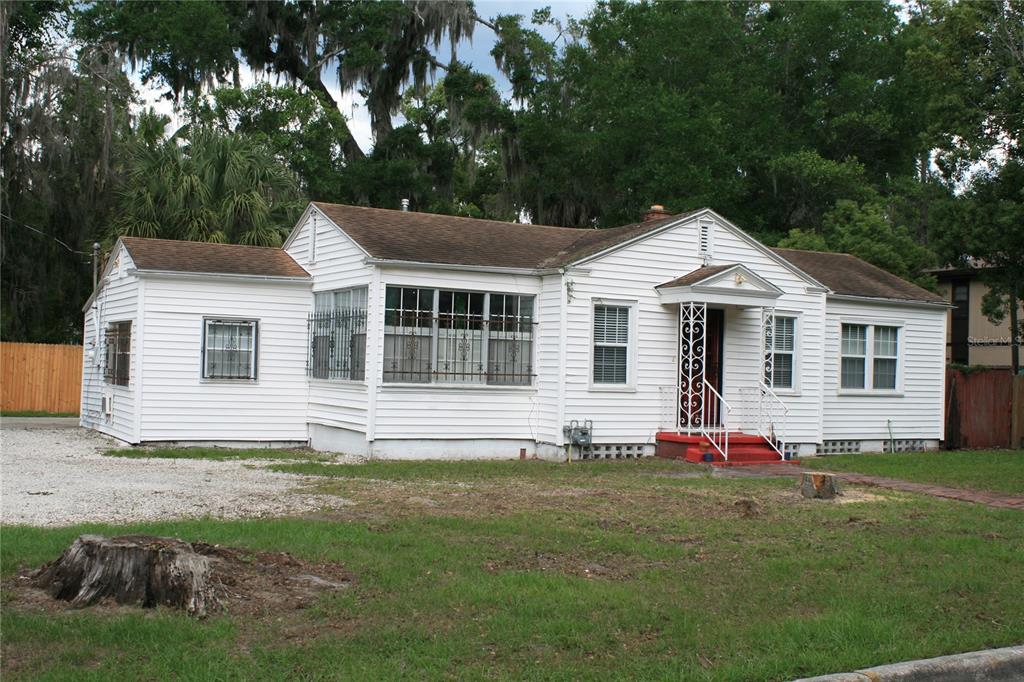 A white, single-story house with horizontal siding, a gabled roof, and a small front porch — 1822 NW 6TH AVENUE, GAINESVILLE, FL
