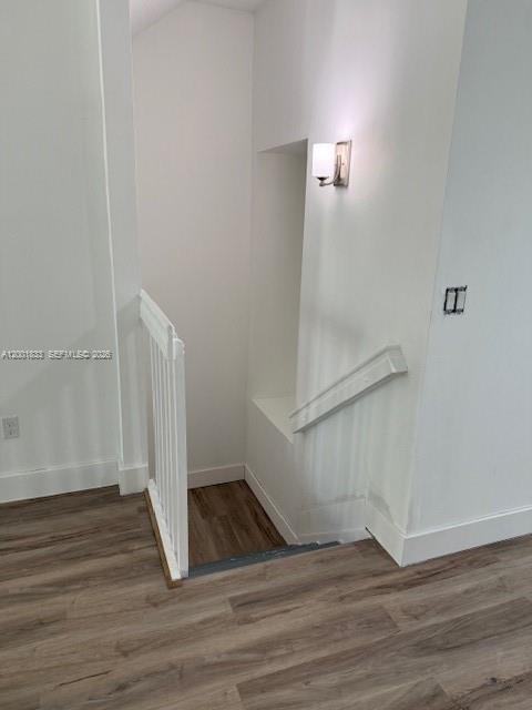 A staircase with white railings leads down to a lower level with wood-look flooring — BOYNTON BEACH, FL
