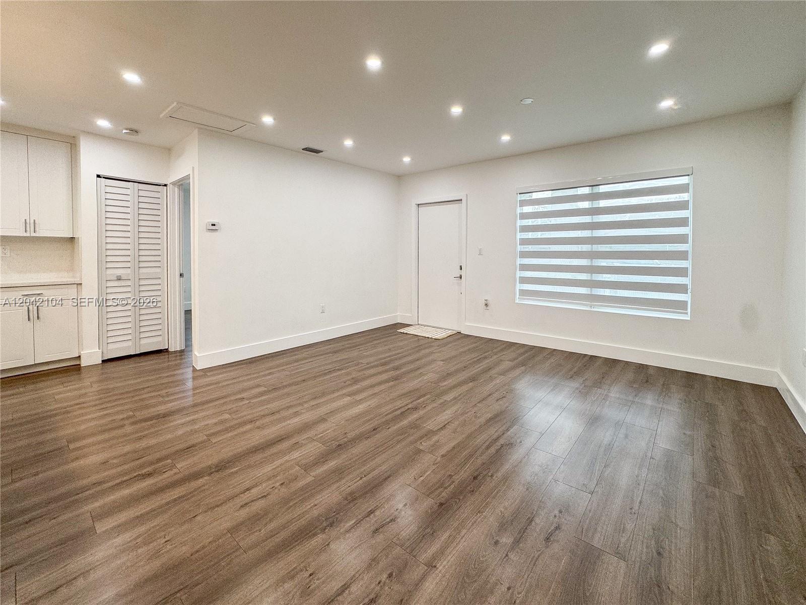 A room with white walls, recessed lighting, wood-look flooring, a window, and a closet — 1319 NW 40th St, Miami FL 33142, MIAMI, FL