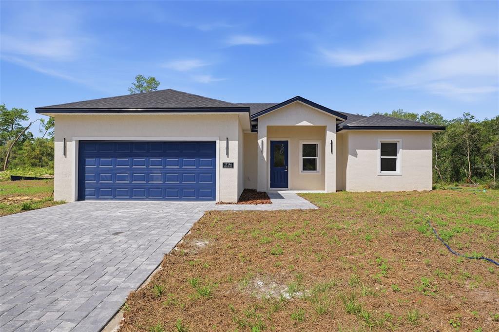 A single-story house with a blue garage door, blue front door, and paved driveway — 17146 SW 41ST CIRCLE, OCALA, FL