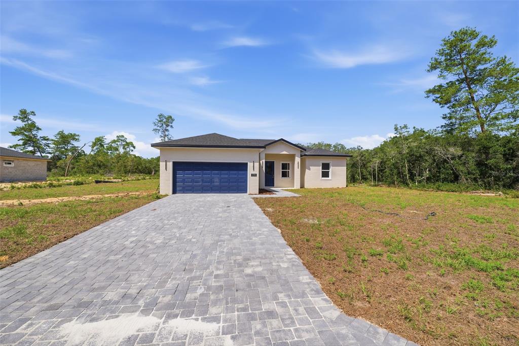 A single-story house with a blue garage door and a paved driveway sits on a lot — 17146 SW 41ST CIRCLE, OCALA, FL