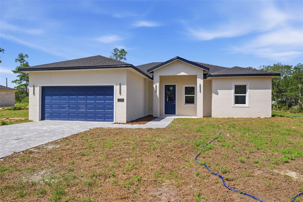 A single-story house with a blue garage door, blue front door, and a paved driveway — 17146 SW 41ST CIRCLE, OCALA, FL