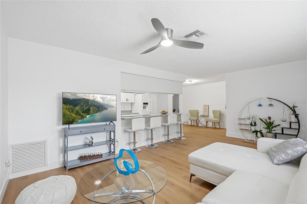 A living room features a white sectional sofa, a glass coffee table, and a breakfast bar — 1318 S HILLCREST AVENUE, CLEARWATER, FL