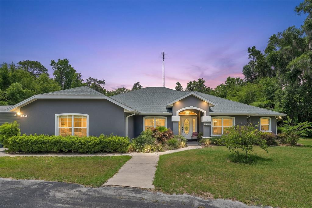 A single-story gray house with a concrete walkway and a large antenna on the roof — 50 NE 35TH STREET, OCALA, FL