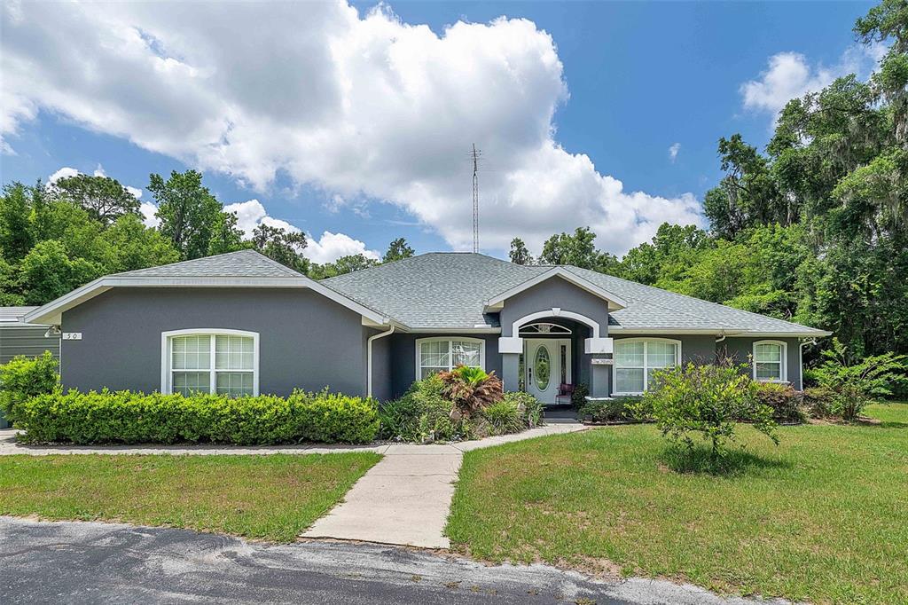 A gray single-story house with a shingled roof and a front walkway — 50 NE 35TH STREET, OCALA, FL