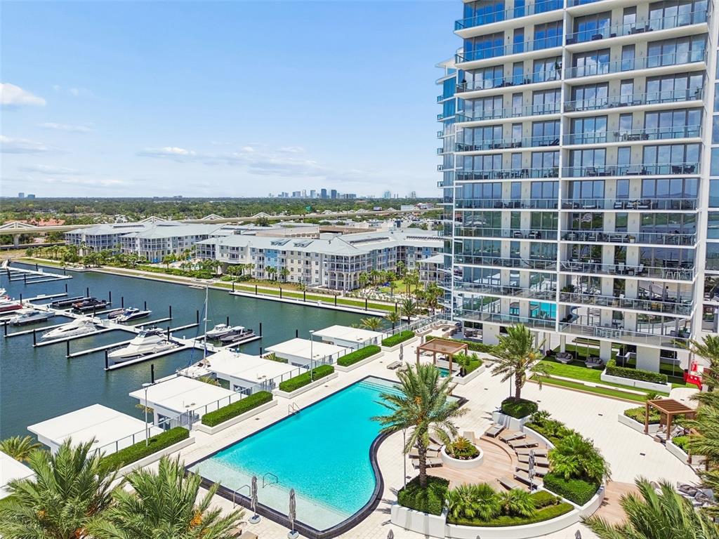 An aerial view shows a swimming pool, a marina with boats, and a high-rise building — 5120 MARINA WAY UNIT 11003, TAMPA, FL