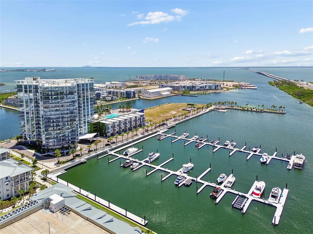 An aerial view shows a marina with docked boats next to a large residential building — 5120 MARINA WAY UNIT 11003, TAMPA, FL