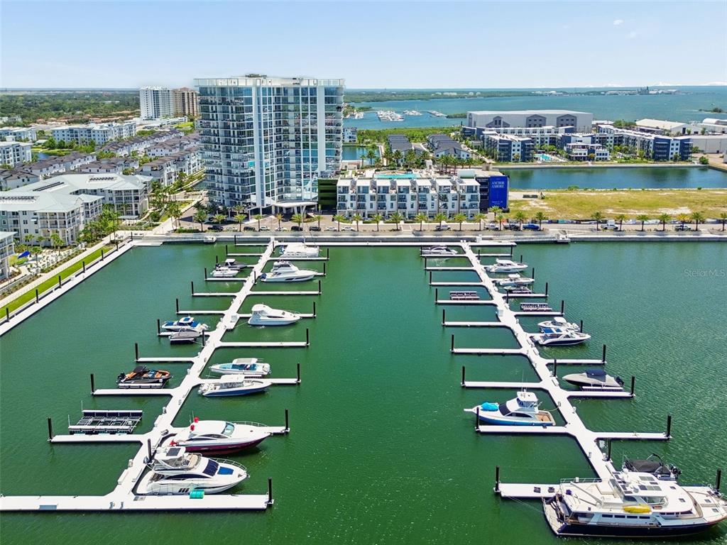 An aerial view shows a marina with numerous docked boats in front of waterfront apartment buildings — 5120 MARINA WAY UNIT 11003, TAMPA, FL