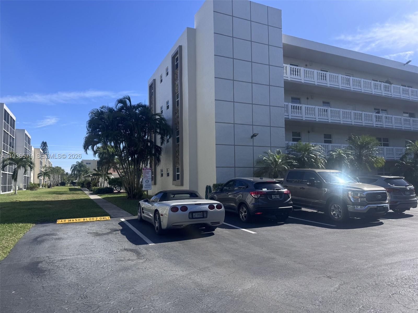 A parking lot with several cars sits in front of a multi-story apartment building — 1025 SE 3rd Ave # 102, Dania Beach FL 33004, DANIA BEACH, FL