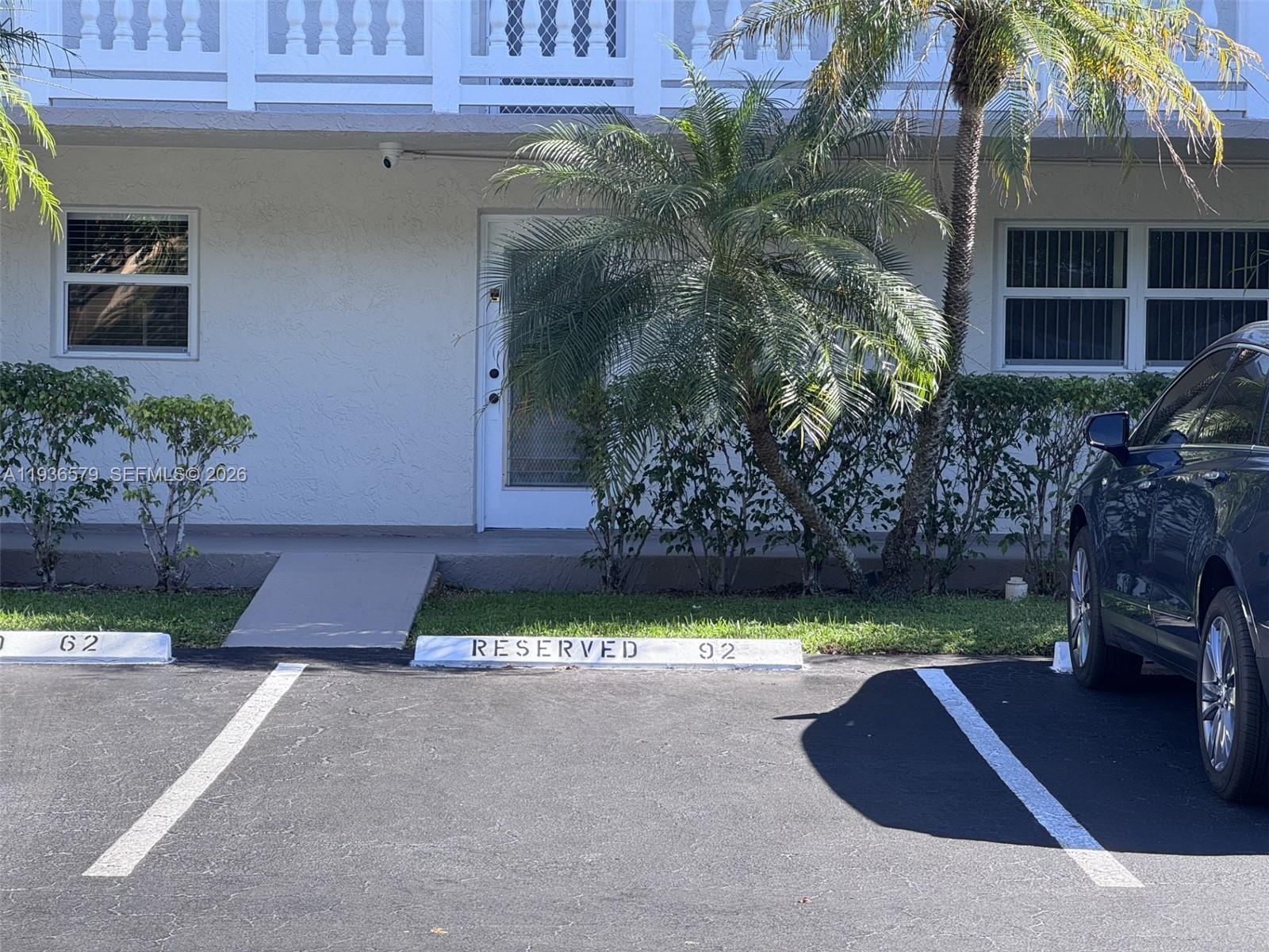 A ground-level view of a building exterior with a reserved parking space numbered 92 — 1025 SE 3rd Ave # 102, Dania Beach FL 33004, DANIA BEACH, FL