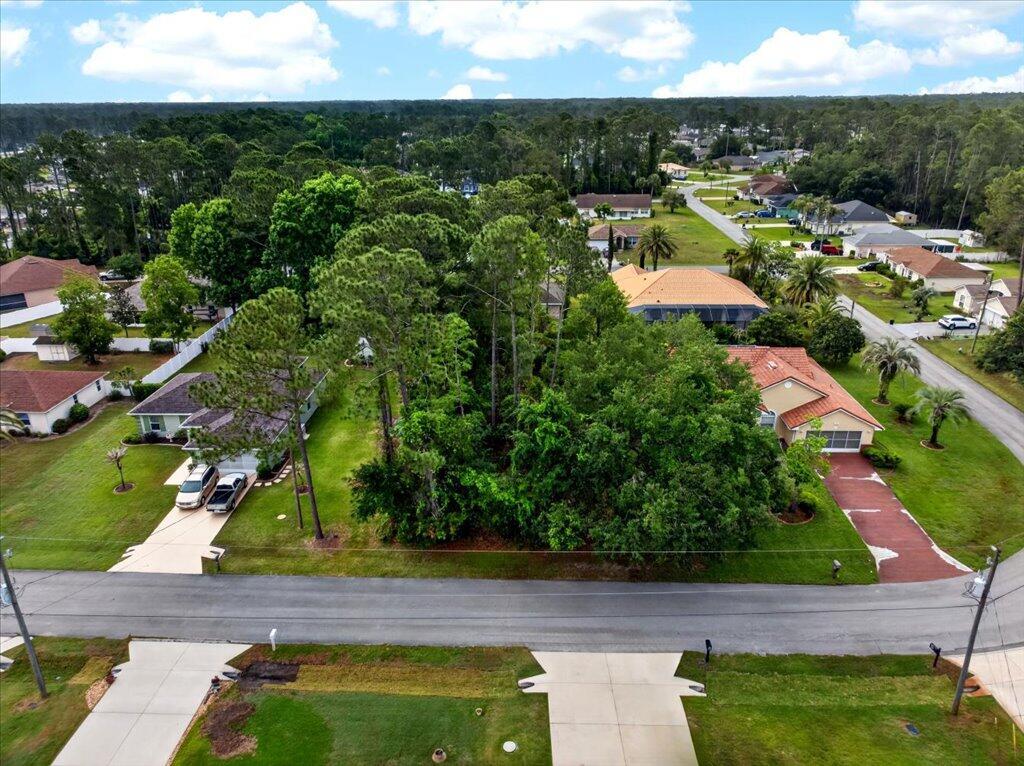 An aerial view shows a wooded vacant lot situated between two residential houses — 112 Ryberry Drive, Palm Coast FL 32164, PALM COAST, FL