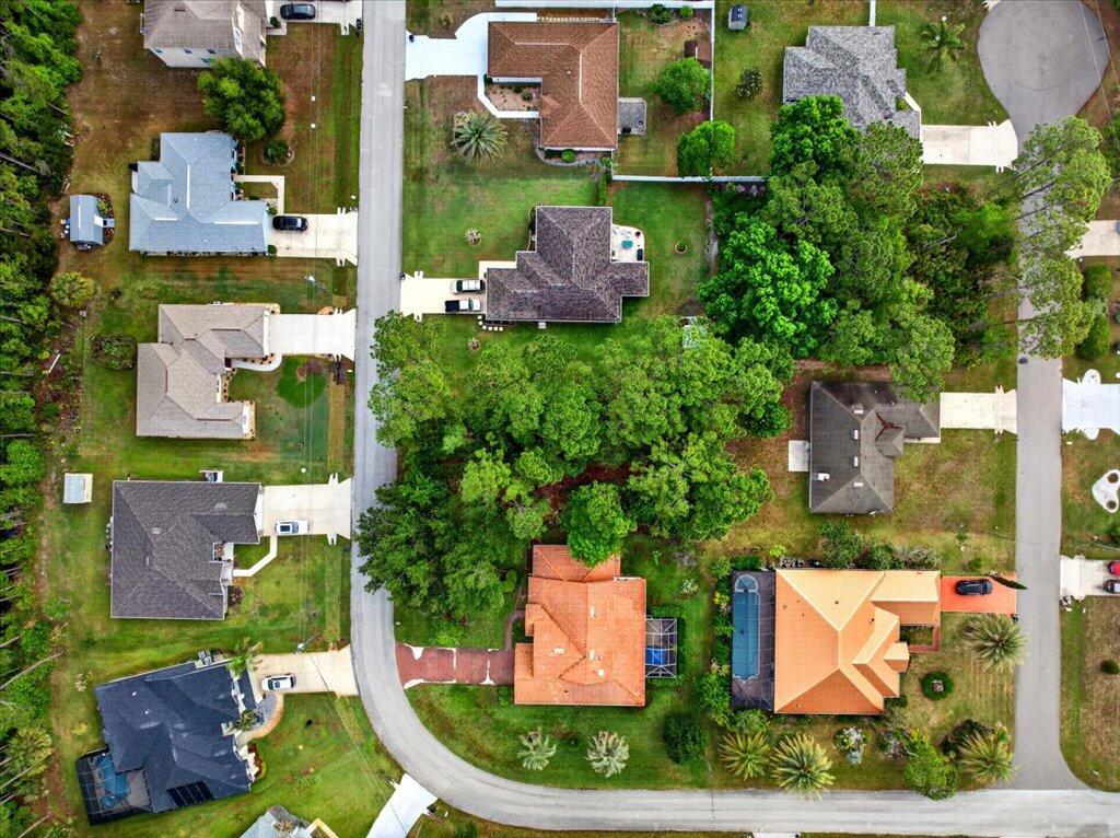 An aerial view shows several suburban houses with driveways, lawns, and trees along a road — 112 Ryberry Drive, Palm Coast FL 32164, PALM COAST, FL