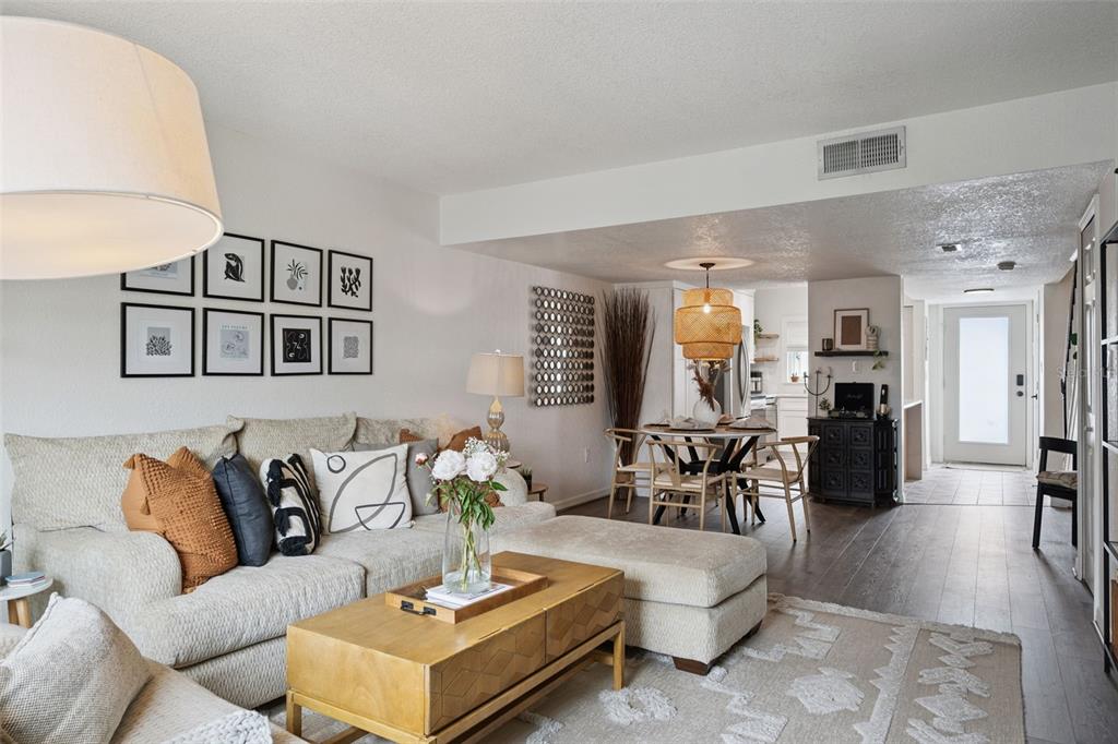 A living room with a sectional sofa, wooden coffee table, and an adjacent dining area — 1922 CONWAY ROAD UNIT 4, ORLANDO, FL