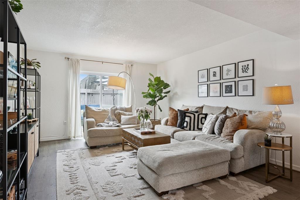 A living room features a sectional sofa, a coffee table, and a gallery wall — 1922 CONWAY ROAD UNIT 4, ORLANDO, FL