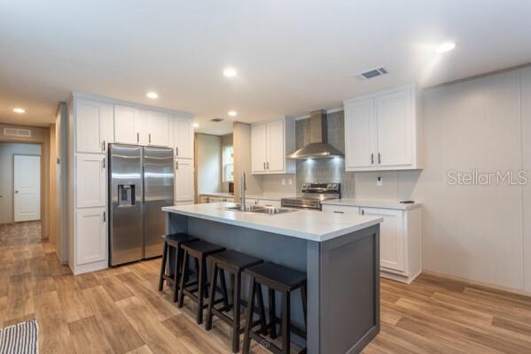 A kitchen with white cabinets, a gray island with stools, and stainless steel appliances — 5631 IRONWOOD AVENUE, BUNNELL, FL