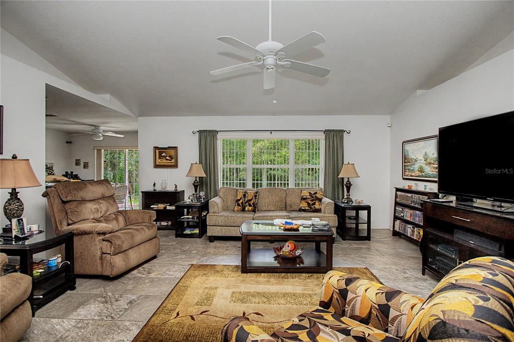 A living room features tile floors, a ceiling fan, a sofa, and a television — 10908 SW 53RD CIRCLE, OCALA, FL