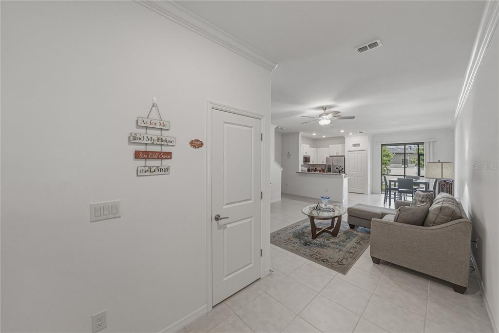 A blue two-story townhouse exterior features three garage doors and a small front yard — 30688 VERIDIAN WAY, WESLEY CHAPEL, FL
