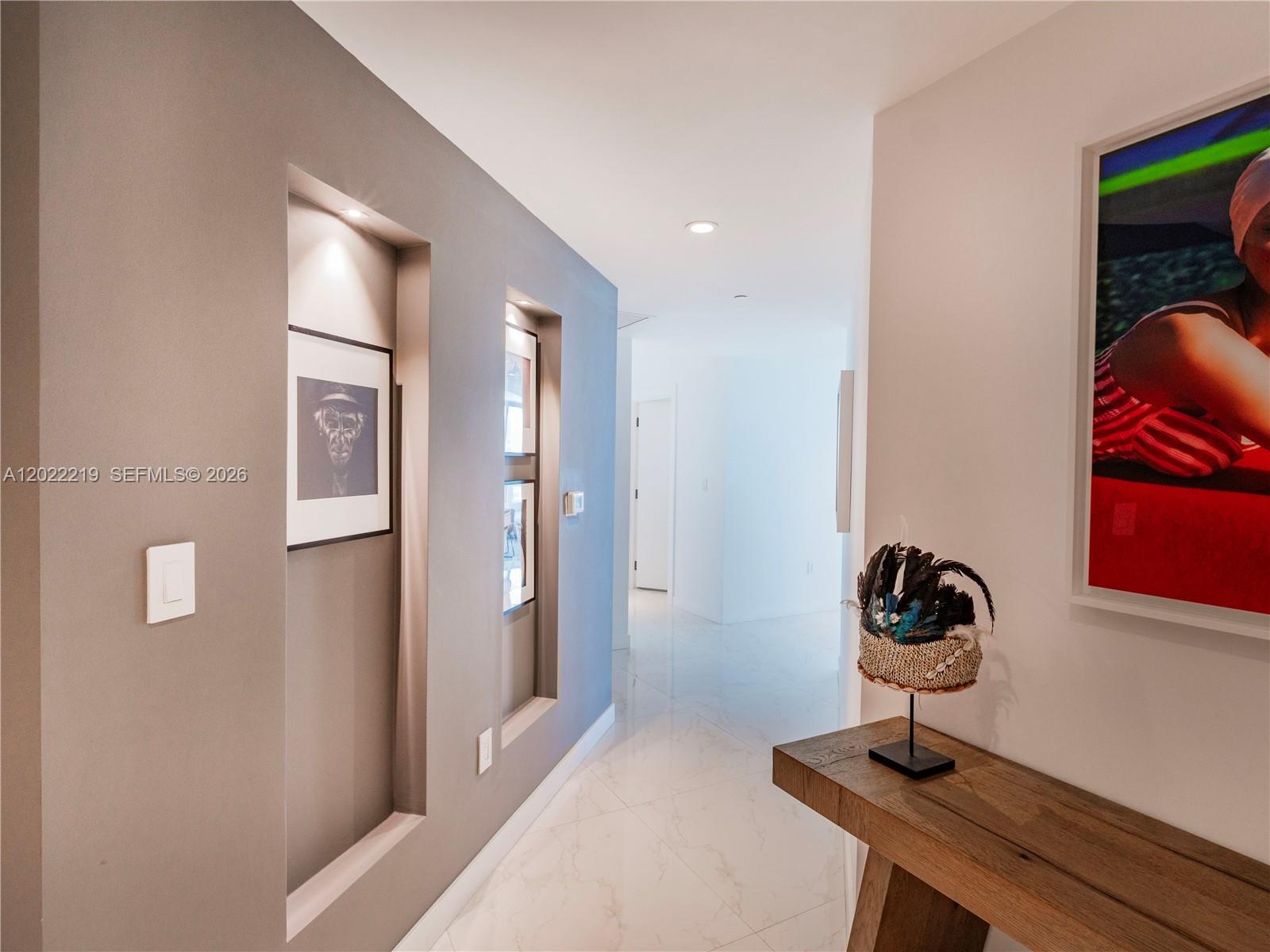 A hallway features recessed wall niches, marble flooring, and a wooden console table — 1300 S Miami Ave # 2901, Miami FL 33130, MIAMI, FL