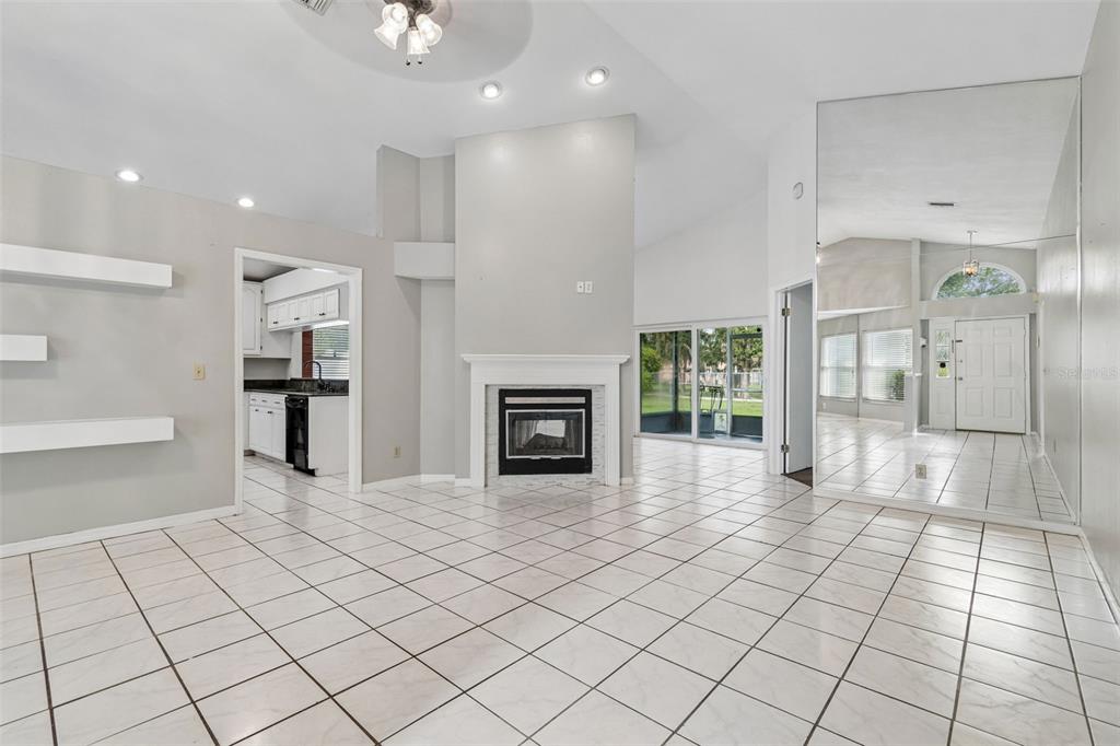 A living room with white tile floors, a fireplace, and a large wall mirror — 4133 BARRET AVENUE, PLANT CITY, FL
