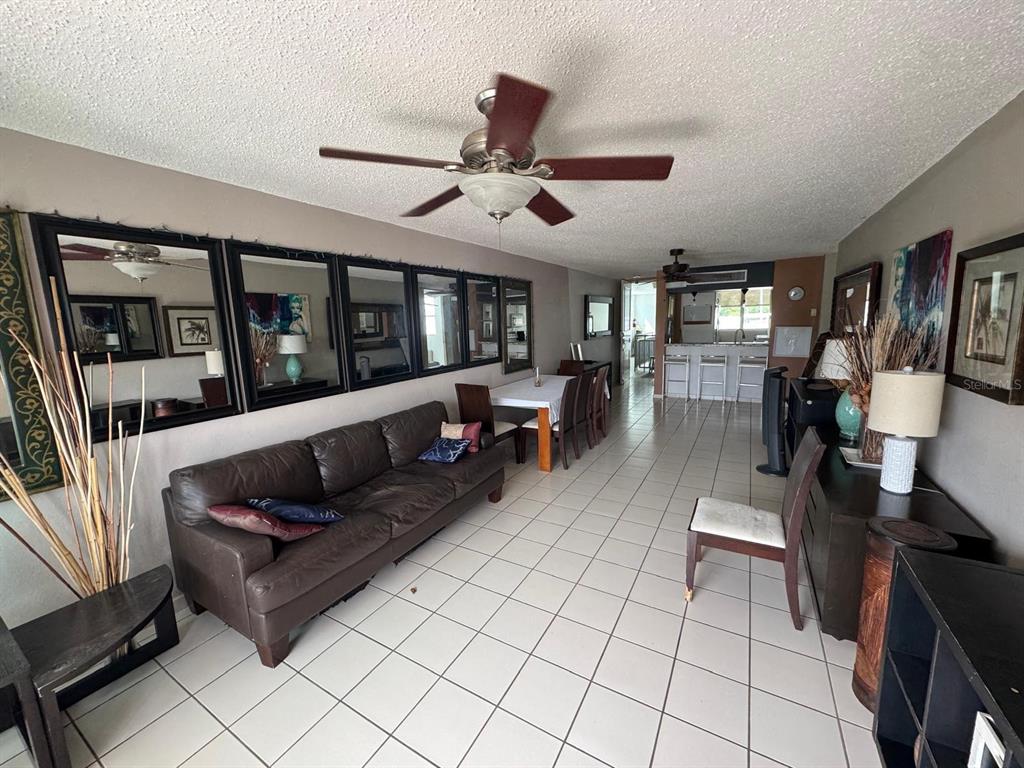 A living and dining area features a brown leather sofa, tiled floors, and wall mirrors — Carr. 199 PASEO DEL BOSQUE UNIT 3-507, SAN JUAN, PR
