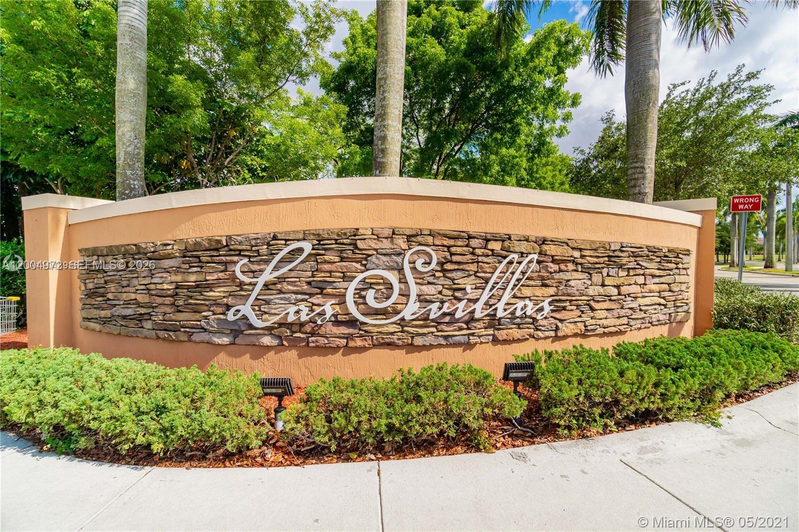 A stone and stucco monument sign for Las Sevillas stands in front of palm trees — 10012 NW 7th St # 209, Miami FL 33172, MIAMI, FL