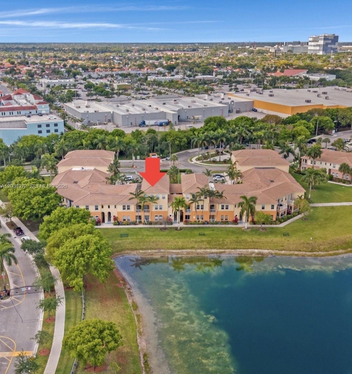 An aerial view of a multi-story apartment building situated next to a lake — 10012 NW 7th St # 209, Miami FL 33172, MIAMI, FL