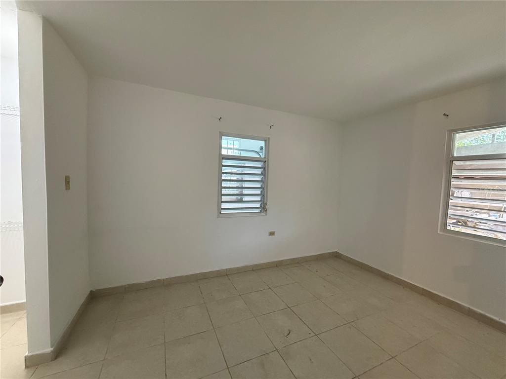 An empty room with white walls, tiled flooring, and two louvered windows — 223 ALMENDRO, JUANA DIAZ, PR