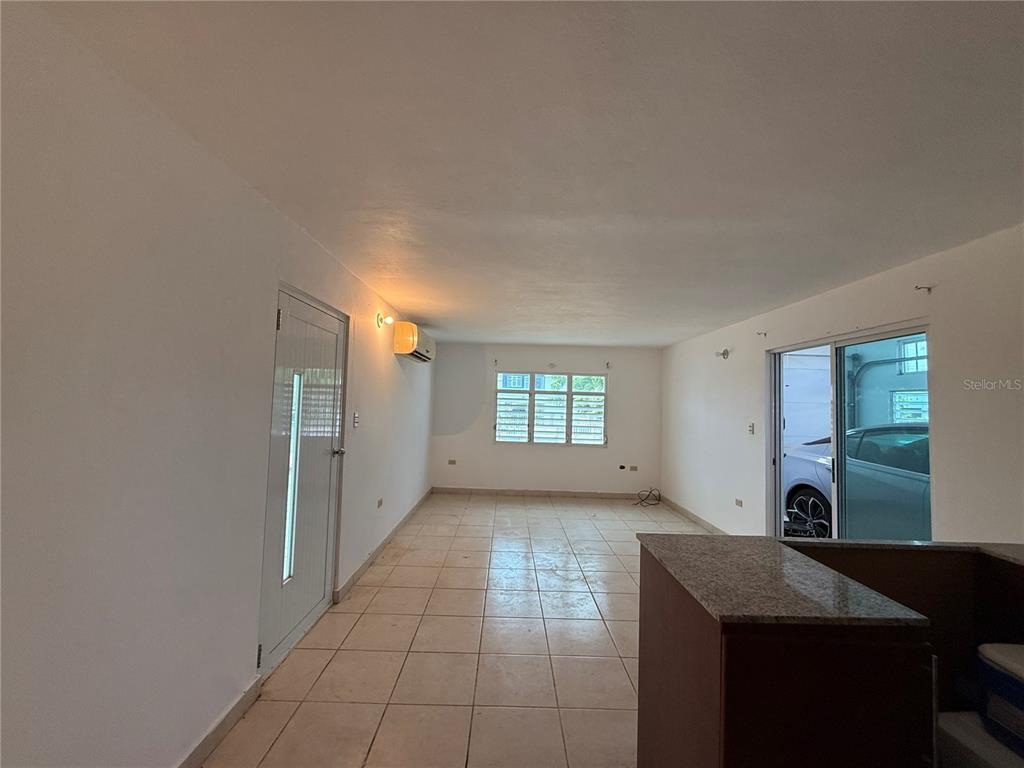 An interior view of a room with white walls, tiled floors, and a sliding glass door — 223 ALMENDRO, JUANA DIAZ, PR