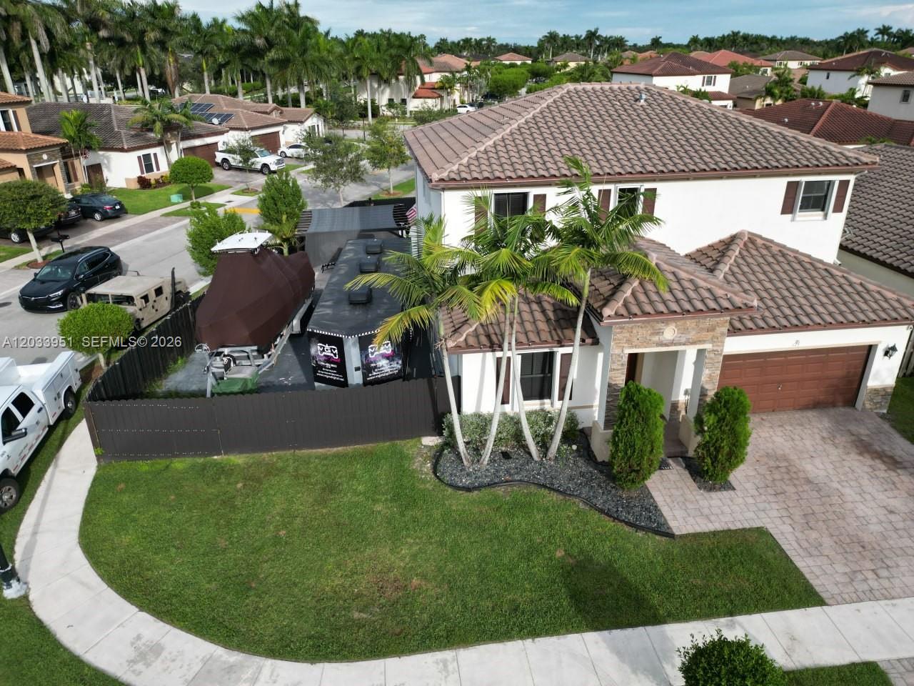 An aerial view of a two-story house with a boat and trailer parked alongside — 175 NE 26th Ave, Homestead FL 33033, HOMESTEAD, FL