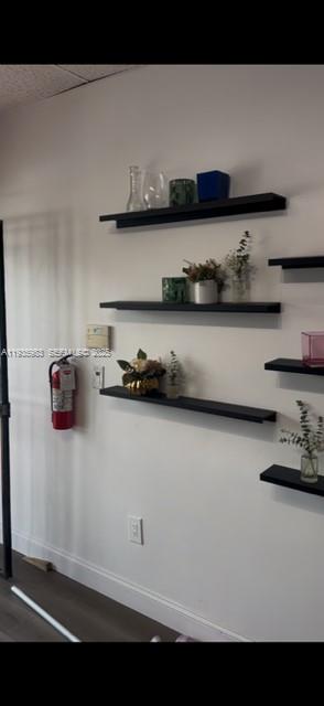 A white wall features several black floating shelves decorated with small plants and glass objects — 4090 NW 167th St, Miami FL 33054, MIAMI, FL