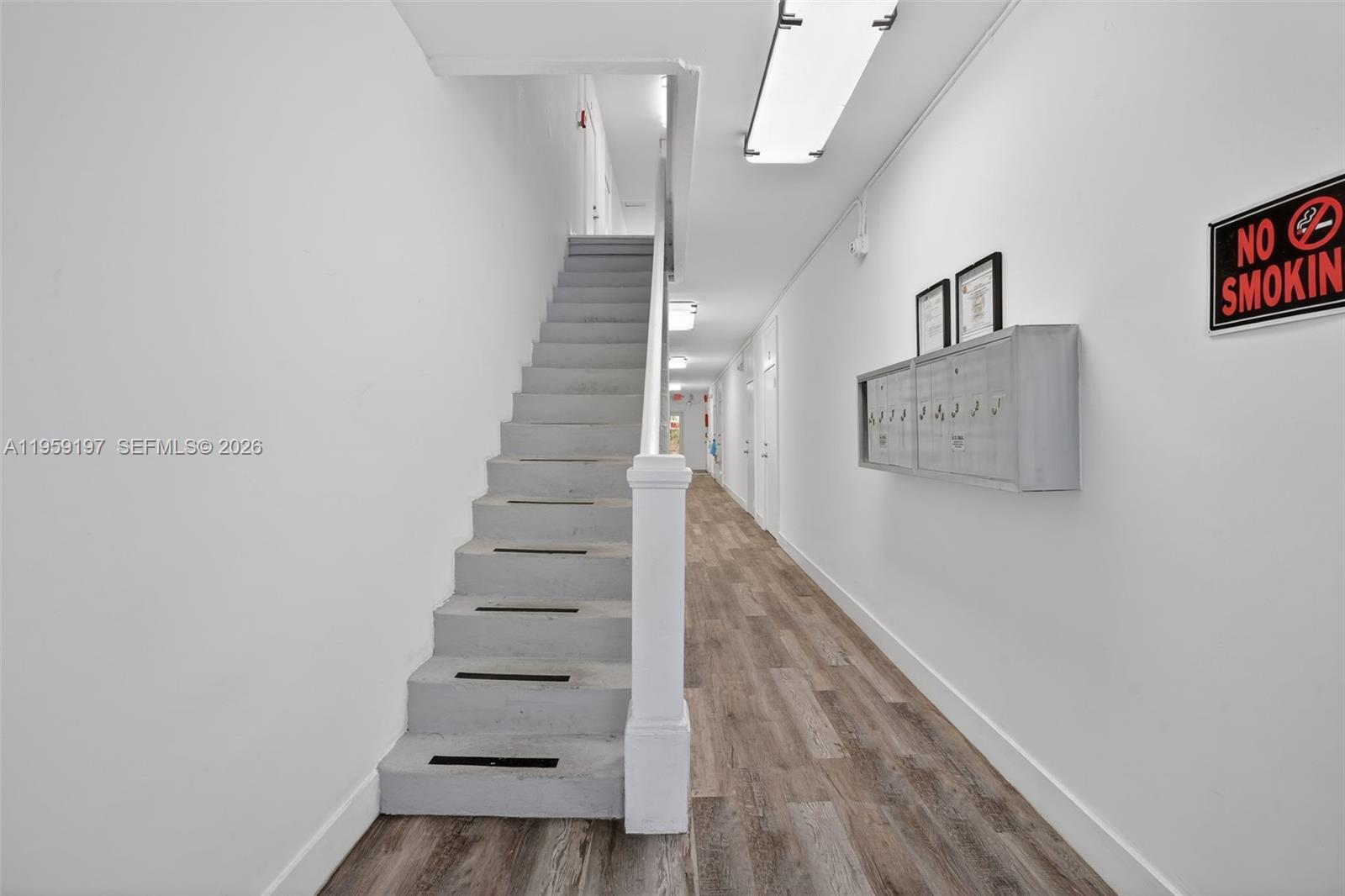 A hallway features light wood-look flooring, a gray staircase, and a wall-mounted mailbox unit — 1630 SW 10th St, Miami FL 33135, MIAMI, FL