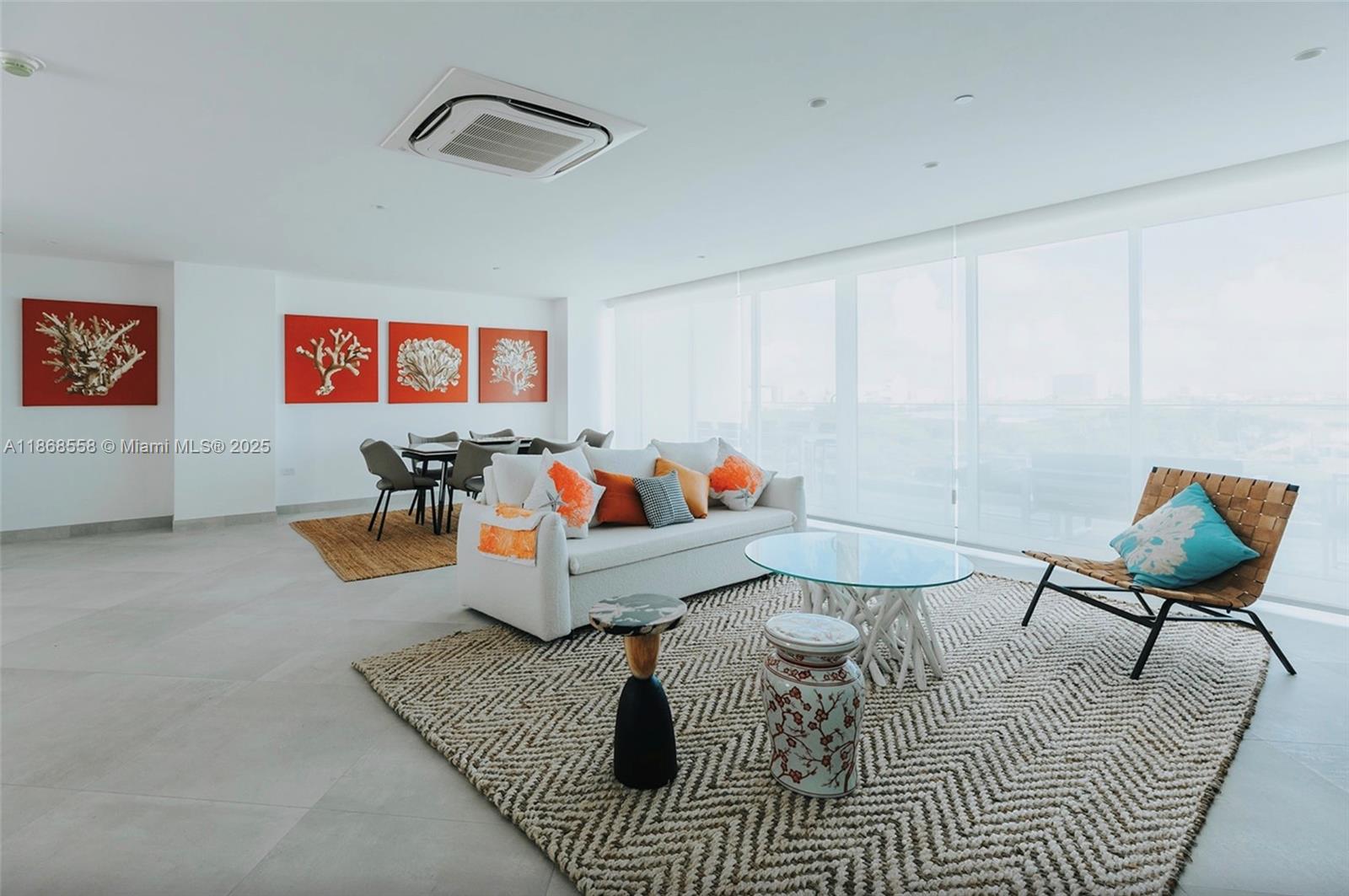 A bright living and dining area features white walls, tile floors, and coral-themed wall art — 1 Irausquin Blvd Eagle beach Aruba # 4B, Ar, Ar