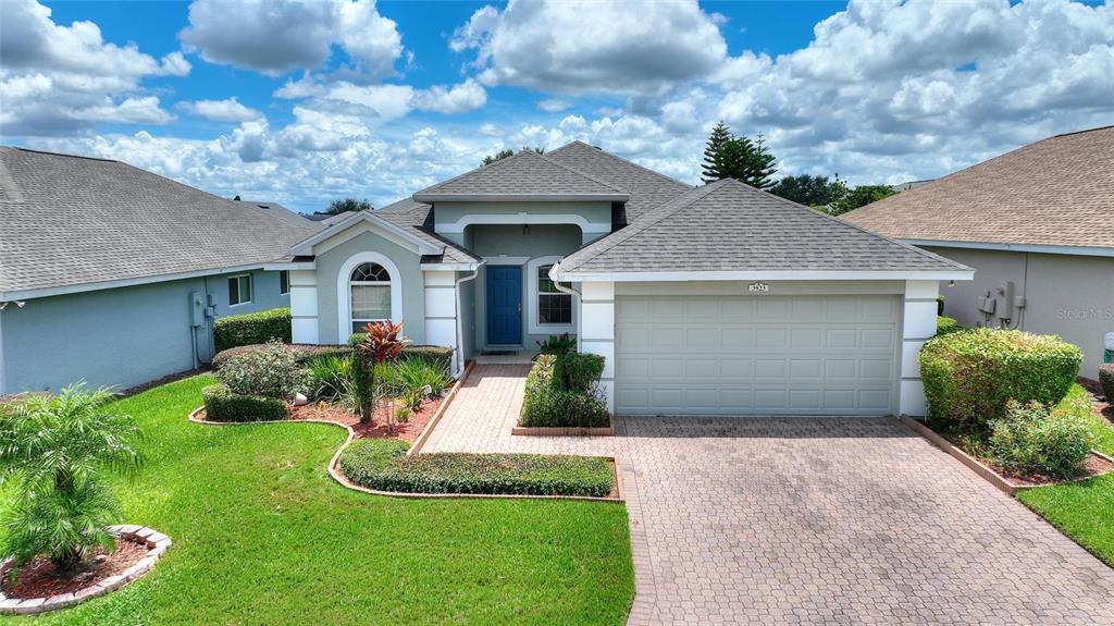 A single-story house with a blue front door, a two-car garage, and a paved driveway — 3923 BALDWIN LANE, WINTER HAVEN, FL