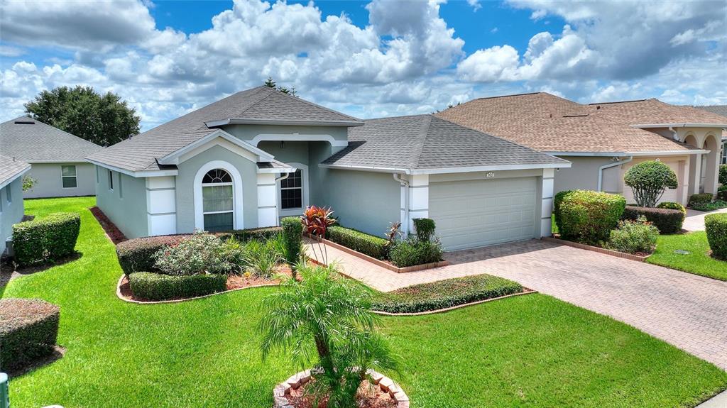 A single-story house with a light green exterior, a two-car garage, and a landscaped lawn — 3923 BALDWIN LANE, WINTER HAVEN, FL